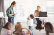 © Yakobchuk Olena - Positive boy answering happy woman while showing at robot. He keeping it in hands. Cheerful man using gadget during lesson. Happy lesson concept