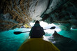 Woman with kayak explores the Marble Caves, paddles inside the cave with interesting patterns on the walls and crystal clear water. Caves are located on the lake of General Carrera, Patagonia, Chile