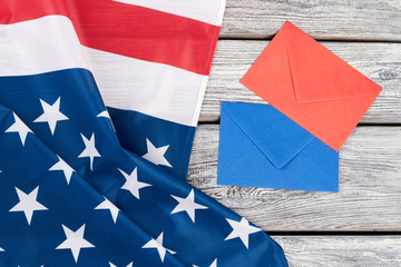 USA flag and colorful envelopes. National flag of America, blue and red envelope on wooden background, top view.