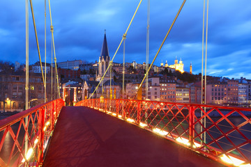 Wall Mural - Panoramic view of Saint Georges church and footbridge across Saone river, Old town with Fourviere cathedral during evening blue hour in Lyon, France