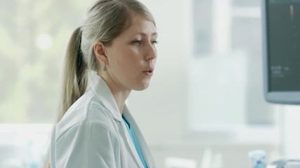 Wall Mural - In the Hospital, Close-up of the Obstetrician Using Transducer for Ultrasound/ Sonogram Screening / Scanning Belly of the Pregnant Woman.  Shot on RED EPIC-W 8K Helium Cinema Camera.