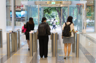 blur people and security at an entrance gate with key card access control smart office building