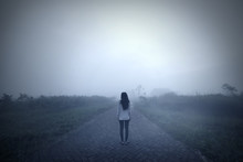 Sad Woman Standing Alone In A Misty Morning