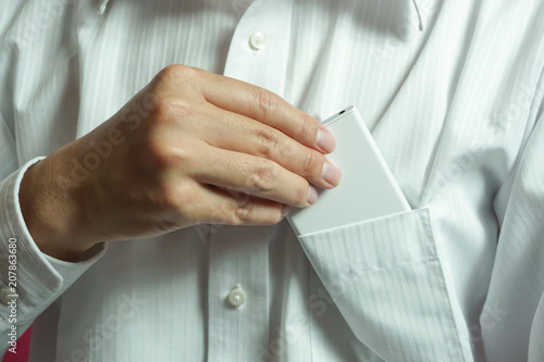 Fotografia, Obraz image of put out a smartphone or, Put smartphone in the shirt breast pocket