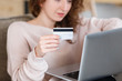 © Rithor - Close up shot of womans hands holding laptop pc and credit card, using online banking application. Selective focus. Online shopping concept