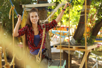 Wall Mural - Teenage girl climbing in adventure park. Summer camp