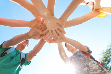 Wall Mural - Group of children putting hands together outdoors. Summer camp