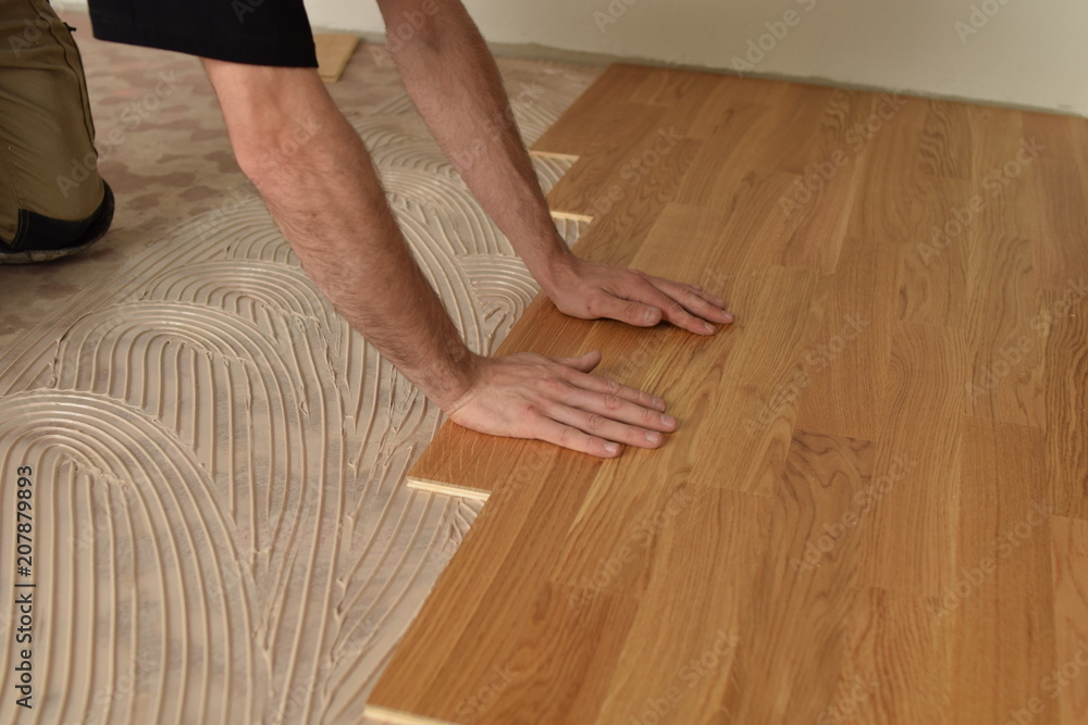 close up of worker installing wood parquet - obrazy, fototapety, plakaty 