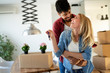 © NDABCREATIVITY - Young couple unpacking cardboard boxes at new home moving in concept
