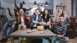 © vadim_key - Friends watch sports on TV, cheer and celebrate. Happy diverse supporters fans sit on couch with popcorn and drinks. 4K.