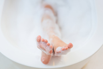 Wall Mural - Women's feet she was bathing in a a bathtub with happiness