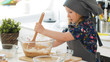 © KONSTANTIN SHISHKIN - Girl baker mixes the mixture for cookies with a whisk