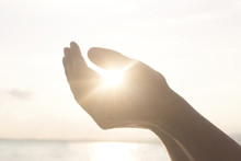 Woman's Hands Hold The Sun And Its Energy