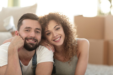 Happy couple lying on the carpet on the blurred background