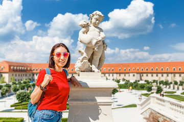 Wall Mural - Happy young woman tourist walking and admiring view of a typical but wonderful flower garden in baroque style in Europe at sunny summer day. Travel destinations concept