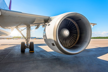 Wall Mural - View of the wing and the big engine of the aircraft in the parking lot at the airport, the platform on a sunny day.