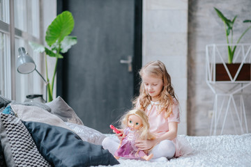 Happy child little girl kissing her favorite newborn doll