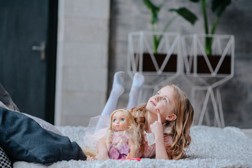 little daughter playing mother with doll.girl with a doll in his hands in dreams