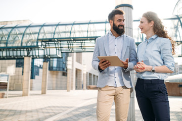 Smiling business man and woman chatting outdoor