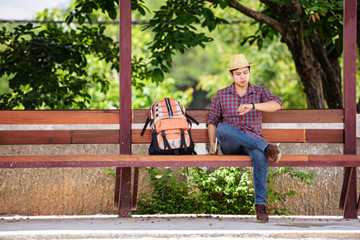 Bus stop with backpackers are watching the clock while waiting for the bus to travel.