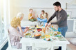 © Seventyfour - Portrait of happy family enjoying dinner together sitting in dining room with  festive table  in modern sunlit apartment, copy space