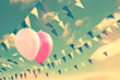 Pink air balloons on sky background with blue and white garlands, vintage summer party concept