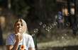 © Maksim - Beautiful blonde woman blowing soap bubbles