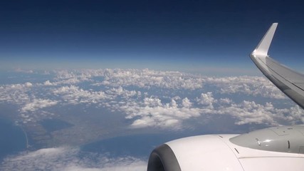 Wall Mural - 4K. Beautiful clouds seen through the window of airplane. Turbine and aircraft wing. Travel in plane. View of traveler in cabin-Adrian