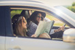 © chika_milan - Two girls having fun driving. One girl driving and other reading the map.
