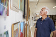 © Monkey Business - Senior Man Looking At Paintings In Art Gallery