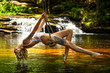 © FashionStock - Young beautiful woman in sexy swimsuit sitting on the swing in wild forest with waterfalls on the background.