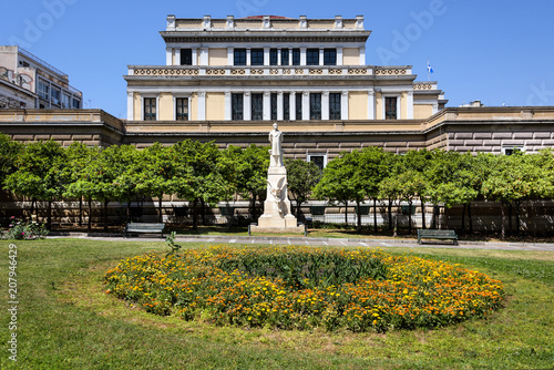 Plakat Grecja, Ateny: Pomnik generała i polityk Nikolaos Trikoupis w zielonym parku piktorów w centrum stolicy Grecji z niebieskim niebem w tle.