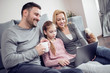 © ivanko80 - Family in living room using laptop