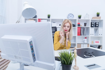 Beautiful girl in yellow dress working at her workplace