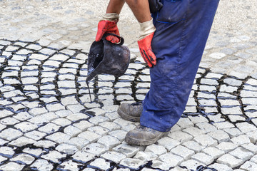 Wall Mural - Worker using tar bucket and pouring bitumen into the joints