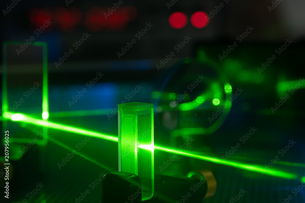 Green laser on optical table in a quantum optics lab. - obrazy, fototapety, plakaty 