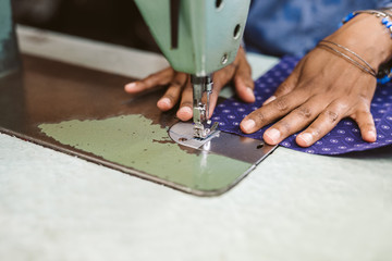 Wall Mural - Closeup of a seamstress stitching textiles using her sewing machine