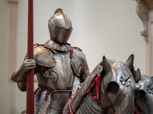 Exhibition Of 15th Century German Plate Armor Around The Time Of Late Middle Ages. The Knight Holds A Land In His Right Arm While Mounted On A Heavily Armored Horse.