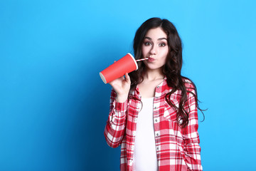 Sticker - Young beautiful woman with paper cup on blue background