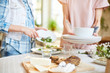 © pressmaster - Crop blur view of faceless female holding plates while other cleaning