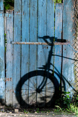 Bicycle shadow on a blue wooden door