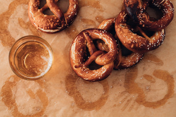 Wall Mural - Traditional German Savory Lye Pretzel with Salt on Piece of Parchment Paper. Poster Banner for Bakery. Copy Space.Top View.Toned image.