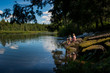 © blurMEDIA/Stocksy - Boy and Girl Sitting on Rock beside Wilderness Stream on Canoe Trip Canada