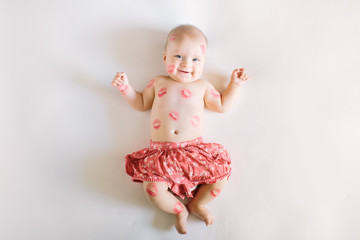 image of adorable child with red kisses on the skin, happy baby girl isolated on white background, l