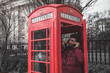 Persona hablando en una cabina de teléfono de Londres, Gran Bretaña