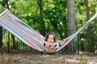 © jakob/Stocksy - Cute young girl relaxing in a hammock eating a watermelon