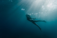 Wide Shot Of A Woman Swimming Underwater