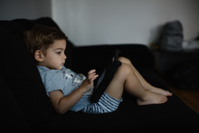 Toddler Watching Cartoons On Computer Tablet