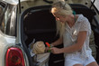 © Milles/Stocksy - Woman with bag in trunk