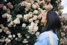Attractive Young Woman Stopping To Smell The Flowers